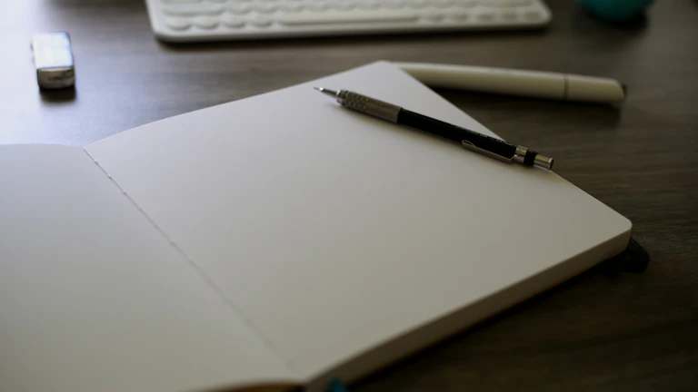 펜으로 일지에 글을 쓰는 사람