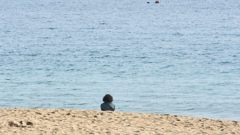 해변에서 노트북을 보며 여유를 즐기는 사람